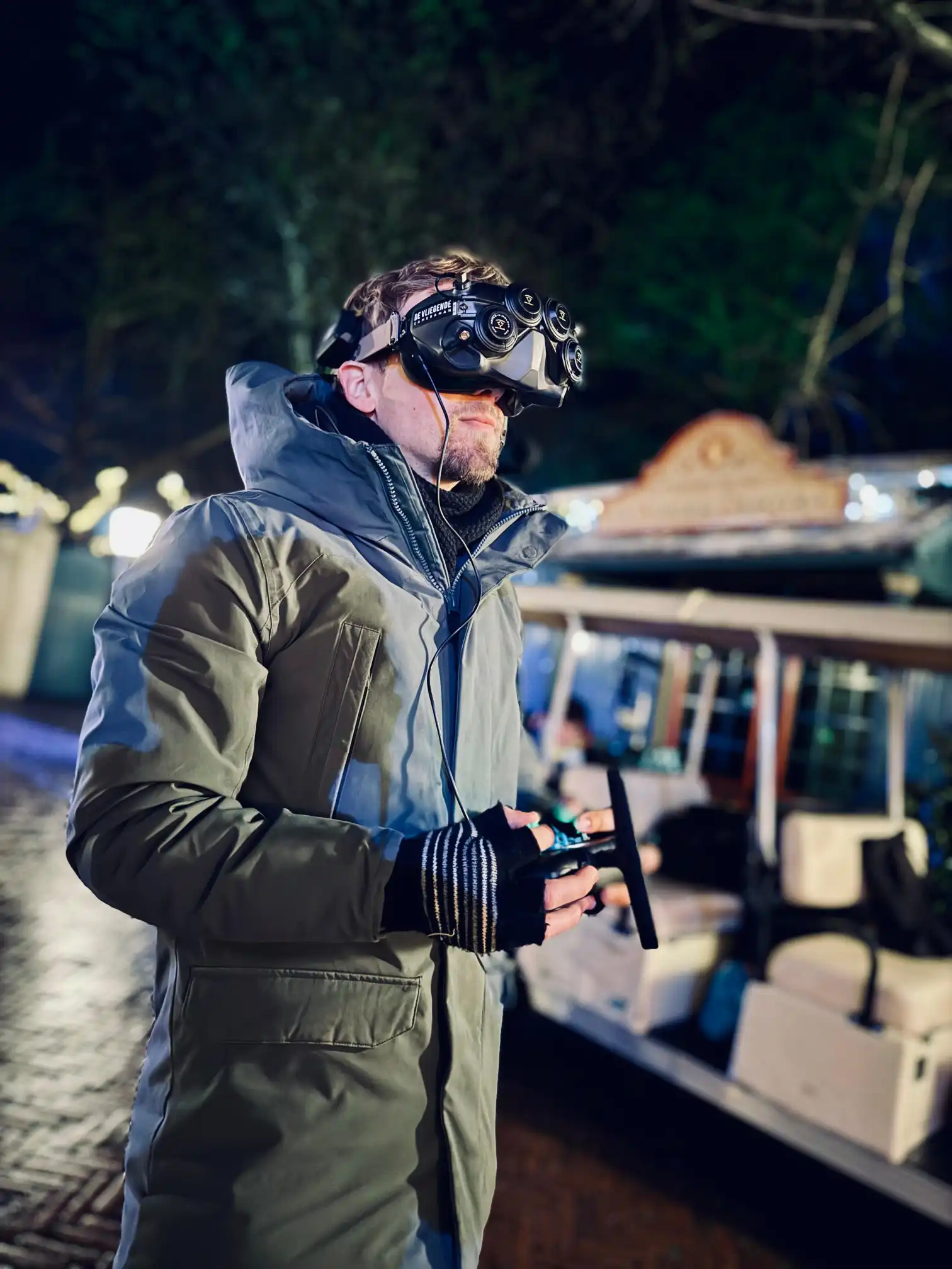 FPV-piloot met goggles vliegt 's avonds bij de Efteling, op de achtergrond een verlicht attractievoertuig