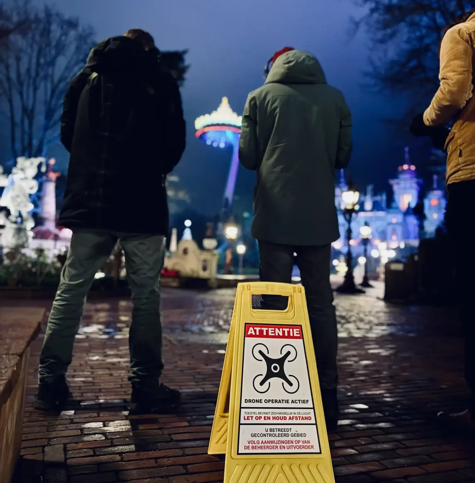 Veiligheidsbord 'Drone operatie actief' bij nacht, met de Efteling op de achtergrond