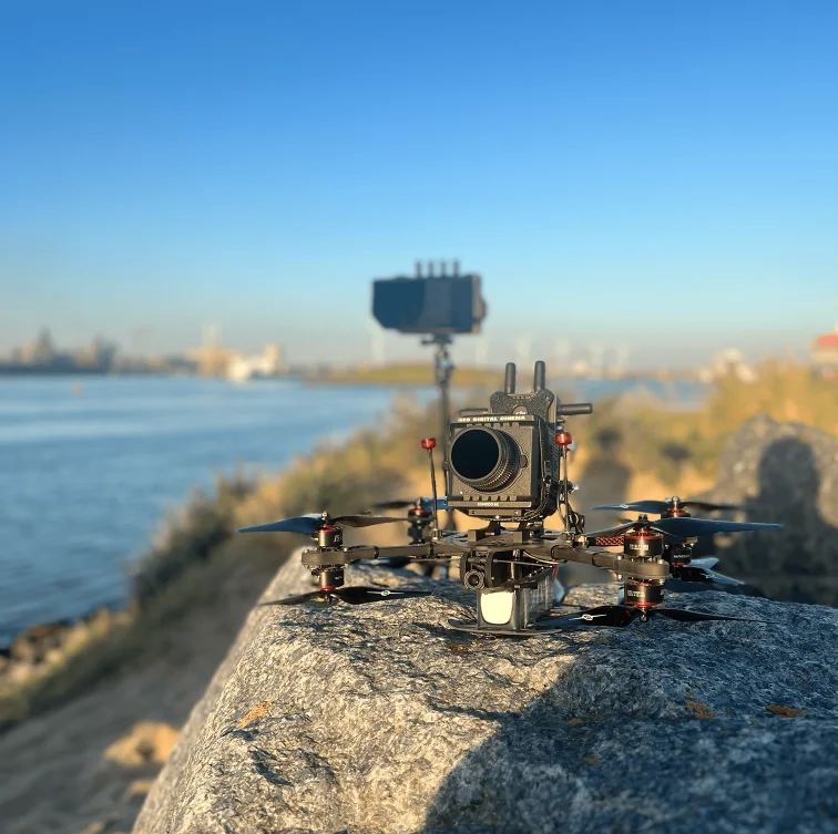 FPV-drone met RED Komodo camera aan de waterkant bij zonsondergang