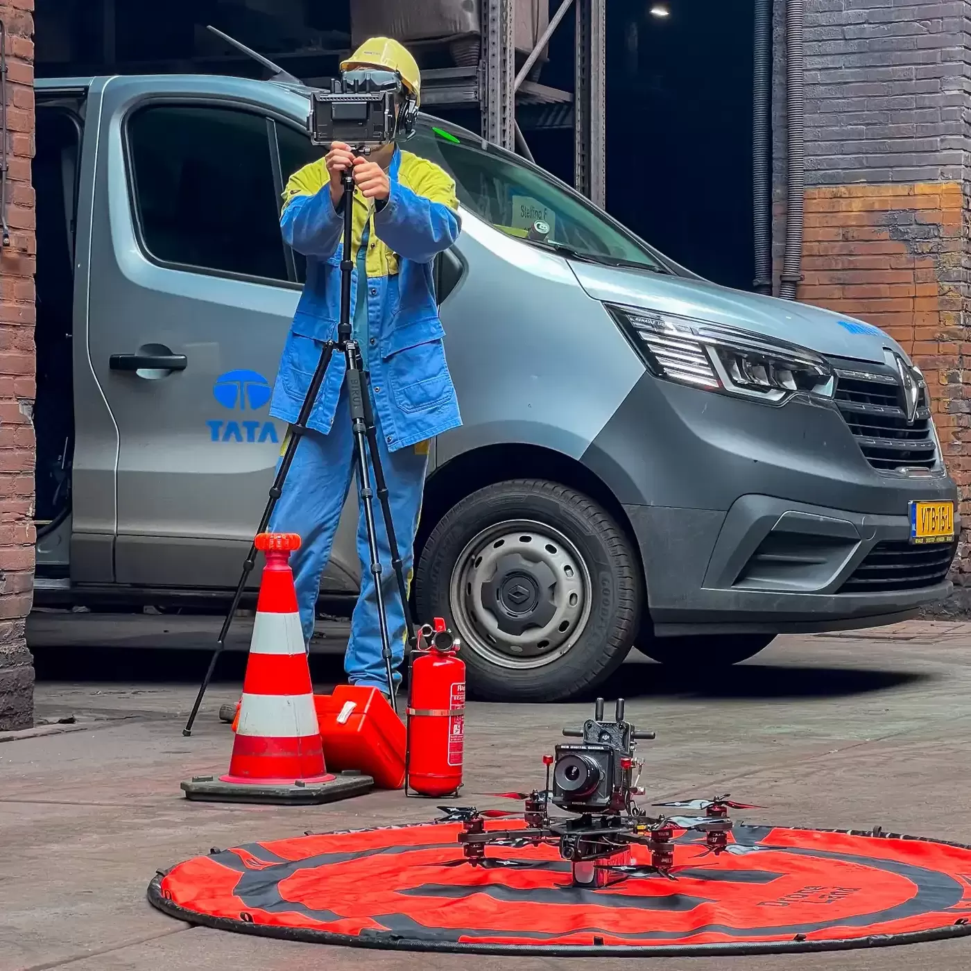 Veiligheidsopstelling op locatie: landingsmat, pion, blusser en de FPV-drone met RED-rig, met een Tata Steel-bedrijfswagen op de achtergrond
