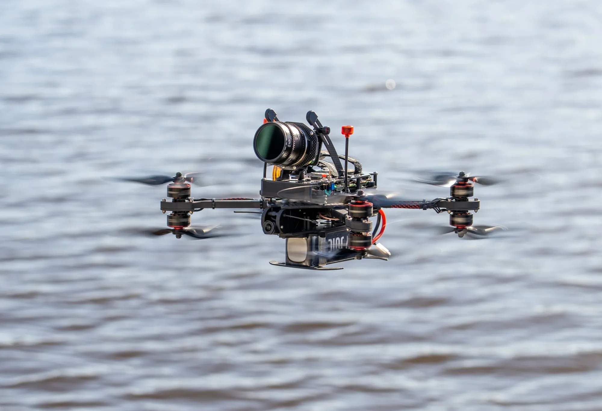 FPV-drone met cinema-camera vliegt laag boven het water van de Zaanse havens